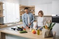 Young attractive couple in love preparing salad from fresh vegetables. Royalty Free Stock Photo