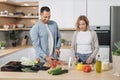 Young attractive couple in love preparing salad from fresh vegetables. Royalty Free Stock Photo