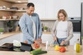 Young attractive couple in love preparing salad from fresh vegetables. Royalty Free Stock Photo