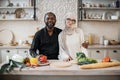 Young attractive couple in love preparing salad from fresh vegetables. Royalty Free Stock Photo