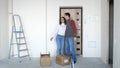 A young attractive couple moving into a new home. A couple is standing on the doorstep next to boxes Royalty Free Stock Photo