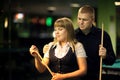 The young attractive couple plays billiards