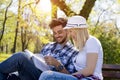 Young attractive couple reading a book together on a park bench Royalty Free Stock Photo