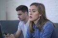 Young attractive couple in relationship problem with internet mobile phone addiction boyfriend ignoring sad neglected and worried Royalty Free Stock Photo