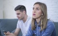 Young attractive couple in relationship problem with internet mobile phone addiction boyfriend ignoring sad neglected and worried Royalty Free Stock Photo