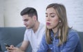 Young attractive couple in relationship problem with internet mobile phone gambling addict boyfriend ignoring sad neglected and bo Royalty Free Stock Photo