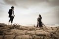 Young attractive couple sharing a moment outdoors on beach rocks Royalty Free Stock Photo