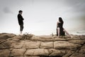 Young attractive couple sharing a moment outdoors on beach rocks Royalty Free Stock Photo