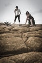 Young attractive couple sharing a moment outdoors on beach rocks Royalty Free Stock Photo