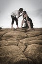 Young attractive couple sharing a moment outdoors on beach rocks Royalty Free Stock Photo