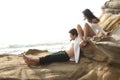 Young attractive couple sharing a moment outdoors on beach rocks Royalty Free Stock Photo