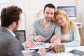 Young attractive couple signing contract with real estate agent Royalty Free Stock Photo