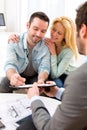 Young attractive couple signing contract with real estate agent Royalty Free Stock Photo