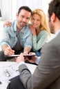 Young attractive couple signing contract with real estate agent Royalty Free Stock Photo