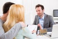 Young attractive couple signing contract with real estate agent Royalty Free Stock Photo