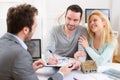 Young attractive couple signing contract with real estate agent Royalty Free Stock Photo