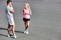 Young attractive couple talking in the road after jogging