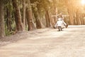 Young attractive couple traveling on scooter along dirt road