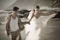 Young attractive couple walking along beach wearing white Royalty Free Stock Photo