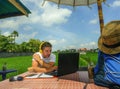 Young attractive digital nomad man working on line outdoors with laptop computer and mobile phone as freelancer and independent jo Royalty Free Stock Photo