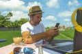 Young attractive digital nomad man working on line outdoors with laptop computer and mobile phone as freelancer and independent jo Royalty Free Stock Photo