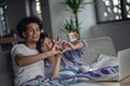 Young attractive diverse couple browsing internet, using laptop computer, smiling.