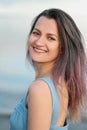 A young attractive dyed hair woman, in a blue dress, on background of seashore and sea. Royalty Free Stock Photo