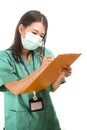 Young attractive and efficient Asian Chinese medicine doctor woman or hospital nurse in protective face mask and green gown during