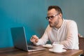 A young attractive European guy businessman in a white shirt eats cheesecake on coffee break in a cafe at a table Royalty Free Stock Photo