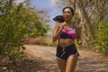 Young attractive and exotic Asian Indonesian runner woman in jogging workout outdoors at countryside road track nature running Royalty Free Stock Photo