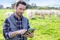 Young attractive farmer using tablet in a field