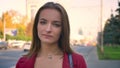 Young attractive female closeup looking on the camera standing on the street, city, expressing rebuke with her eyes