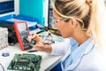 Female electronic engineer checking CPU microchip in laboratory