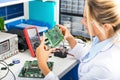 Female electronic engineer checking circuit board in laboratory Royalty Free Stock Photo