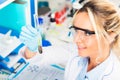 Young attractive female scientist examining test tube with a plant in the laboratory Royalty Free Stock Photo