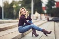 Young attractive female sitting on stone stairs