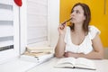 Young attractive female student preparing for exams with textbooks on the table. Learn the lessons. Royalty Free Stock Photo