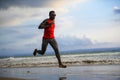 Young attractive fit athletic and strong black African American man running at the beach training hard and sprinting on sea water Royalty Free Stock Photo