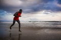 Young attractive fit athletic and strong black African American man running at the beach training hard and sprinting on sea water Royalty Free Stock Photo