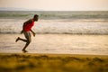 Young attractive fit athletic and strong black African American man running at the beach training hard and sprinting on sea water Royalty Free Stock Photo