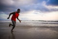 Young attractive fit athletic and strong black African American man running at the beach training hard and sprinting on sea water Royalty Free Stock Photo