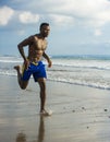 Young attractive fit athletic and strong black African American man running at the beach training hard and sprinting on sea water Royalty Free Stock Photo