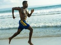 Young attractive fit athletic and strong black African American man running at the beach training hard and sprinting on sea water Royalty Free Stock Photo