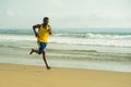 Young attractive fit athletic and strong black African American man running at the beach training hard and sprinting on sea water Royalty Free Stock Photo