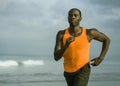 Young attractive and fit black African American man running on the beach doing Summer fitness jogging workout at the sea in sport Royalty Free Stock Photo