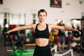 Young attractive fitness girl lifting dumbbells weights on wicker hands in gym. Royalty Free Stock Photo