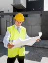 Young attractive foreman worker supervising building blueprints outdoors wearing construction helmet Royalty Free Stock Photo