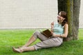 Young attractive fresh woman at the park writes in notebook journal Royalty Free Stock Photo