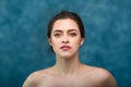 Young attractive girl with black hair fixed behind, big eyes, thick eyebrows and naked shoulders holding hand near face Royalty Free Stock Photo