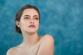 Young attractive girl with black hair fixed behind, big eyes, thick eyebrows and naked shoulders holding hand near face Royalty Free Stock Photo